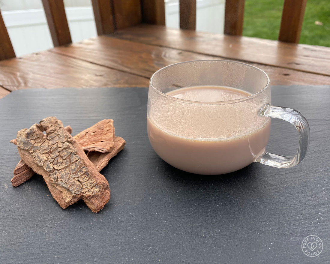 a glass of Arjuna milk on a table outside