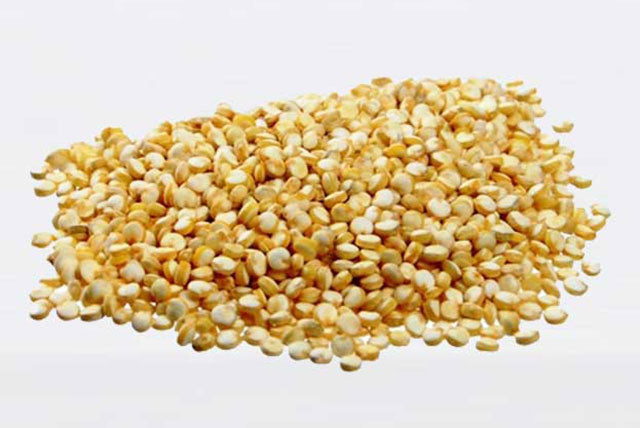 A pile of dry quinoa grains on a white background